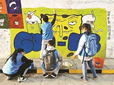 厦门大学学生在修复被游客涂鸦的墙面